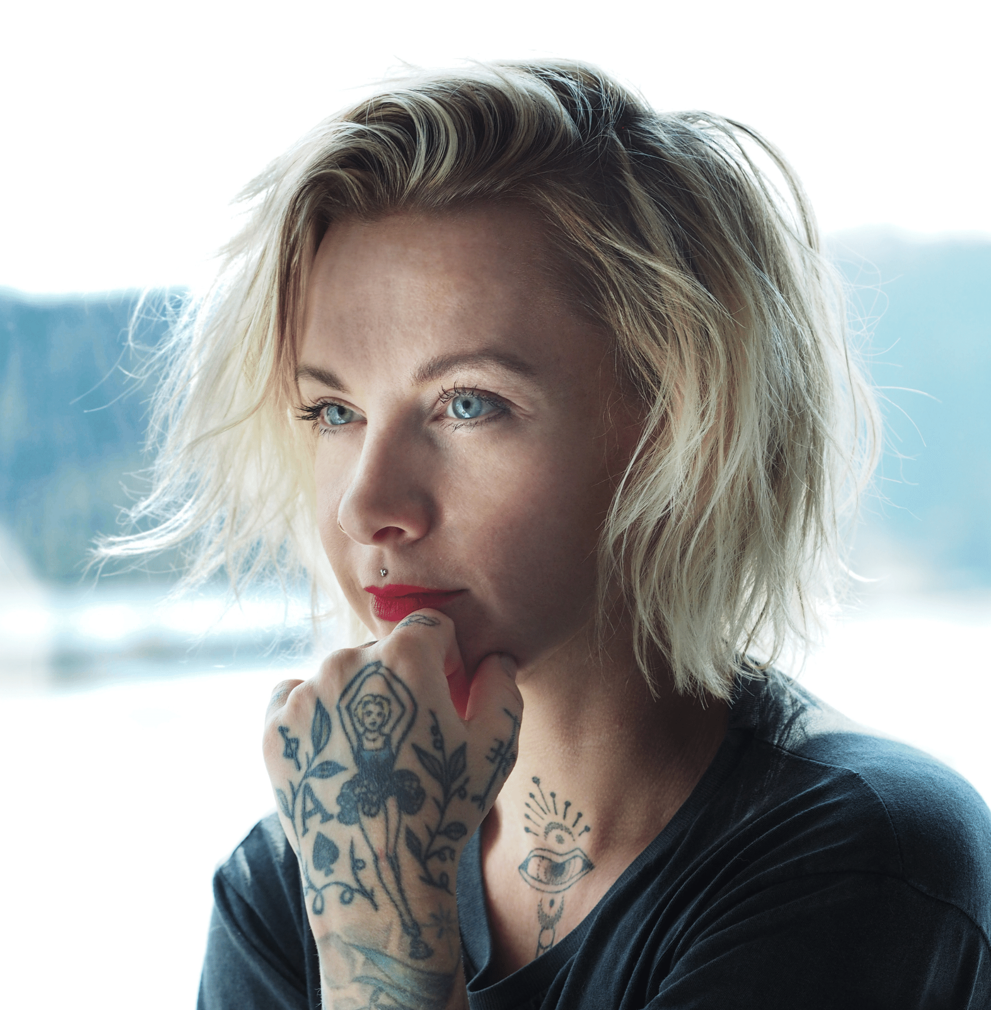 The author, a light-skinned, blue-eyed person with tattoos and tousled blond hair.